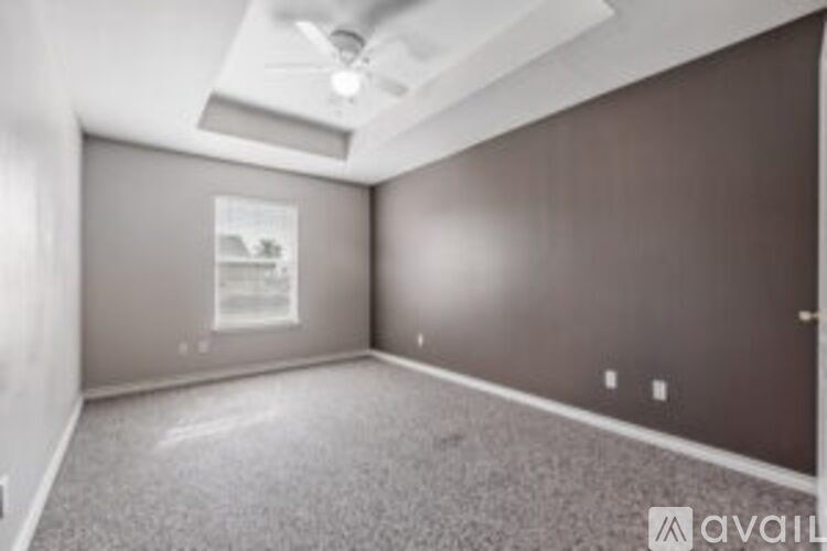 A spacious room with a ceiling fan and a window.