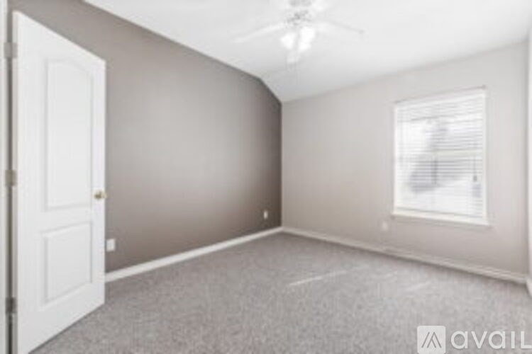 A room with a ceiling fan and a window with blinds.