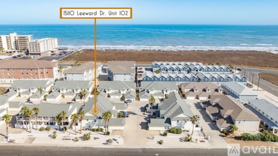 A sign reading "15110 Leeward Dr. Unit 102" is displayed in front of a beachfront apartment complex.