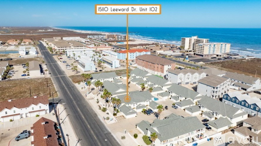 A street view of a coastal area with a sign reading "15110 Leeward Dr. Unit IO2".