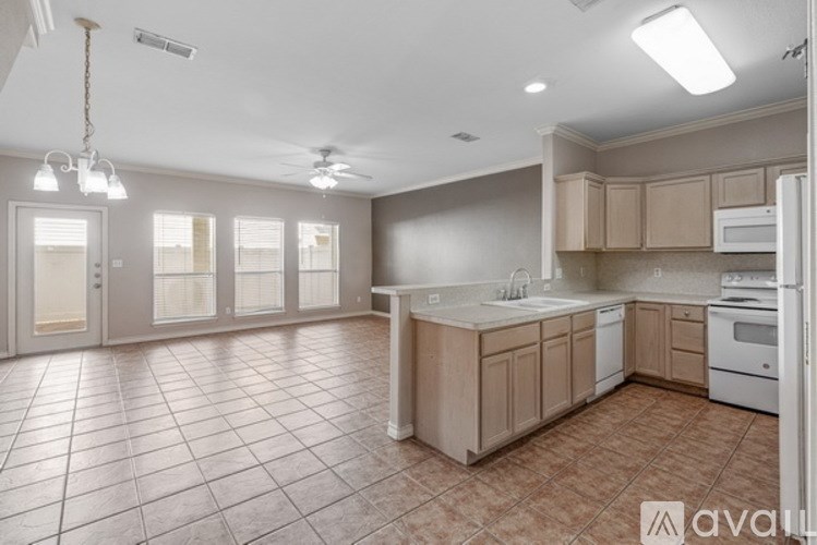 A kitchen with tile flooring and white appliances.