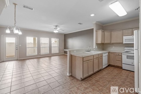 A kitchen with tile flooring and white appliances.
