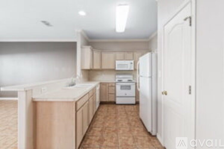 A kitchen with white appliances and wooden cabinets.