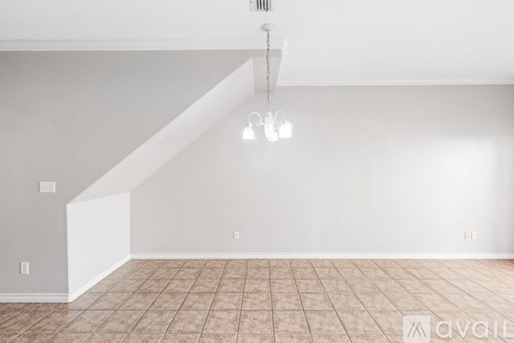 A room with a tiled floor and a staircase.