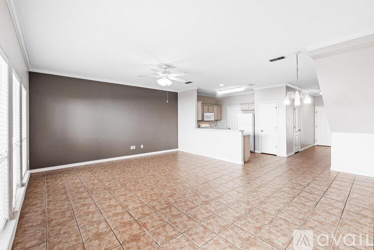 A spacious room with tiled flooring and a ceiling fan.