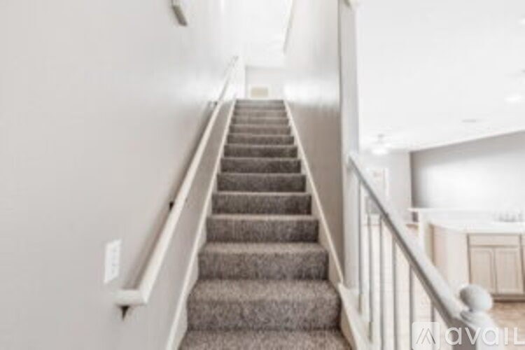 A staircase with a carpeted runner and white railings.