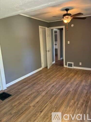 A room with wooden flooring and a ceiling fan.