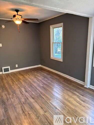 A room with wooden flooring and a ceiling fan.