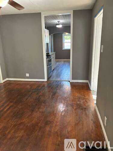 A room with wooden flooring and a white door.