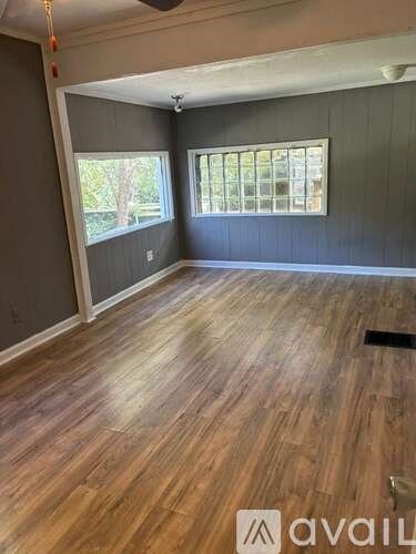 A room with wooden flooring and a window.