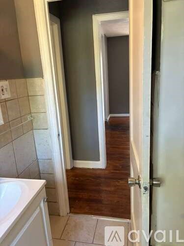 A bathroom with a white sink and a white door.