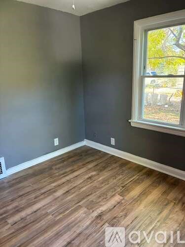 A room with wooden flooring and a window.