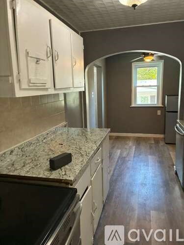 A kitchen with granite countertops and white cabinets.