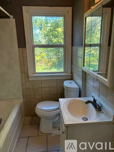 A bathroom with a toilet, sink, and tub.