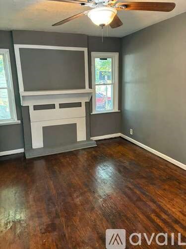 A room with a wooden floor and a television mounted on the wall.