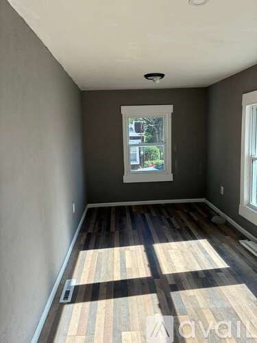 A room with a window and wooden flooring.