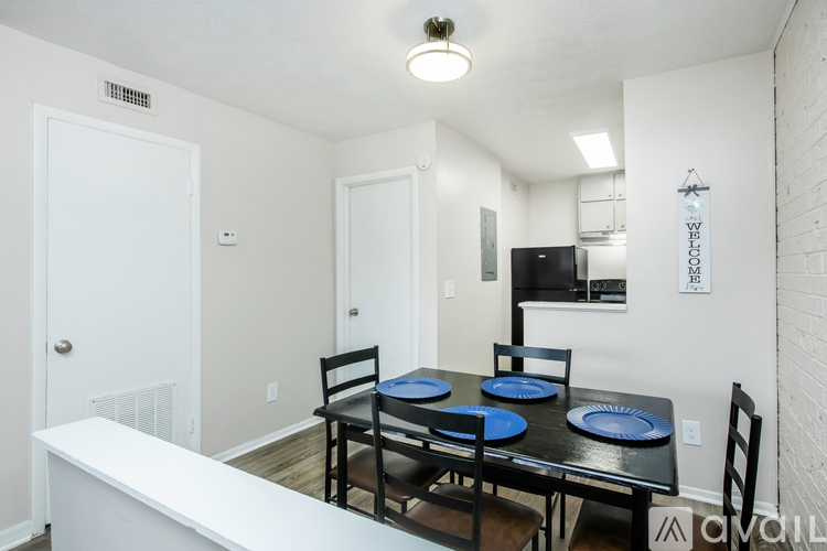 A dining room with a black table and chairs.