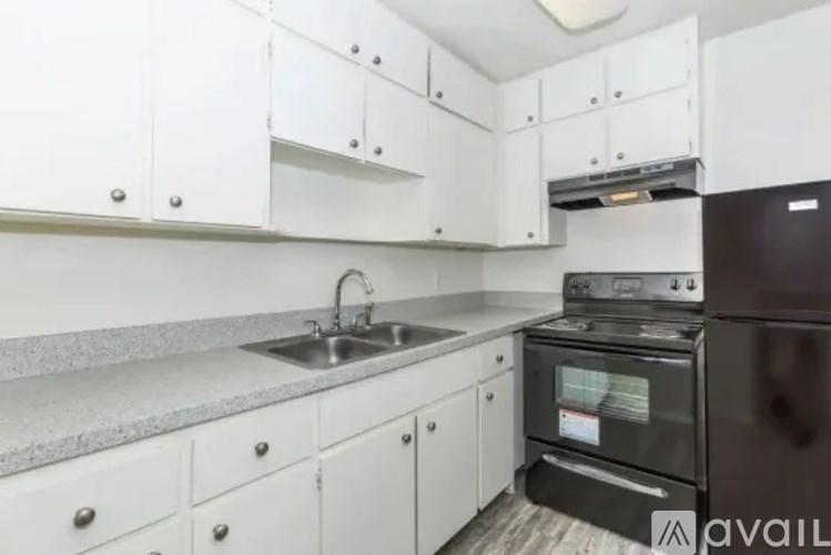 A kitchen with white cabinets and a black oven.