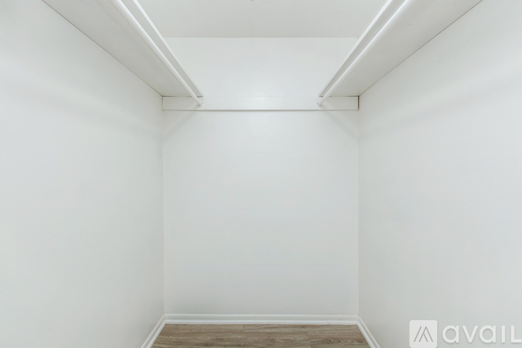 A spacious room with a carpeted floor and a staircase leading to another room.