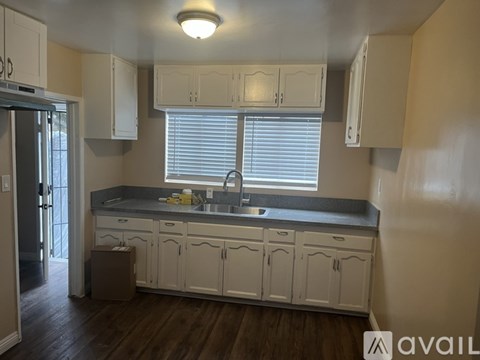 A kitchen with white cabinets and a black countertop.
