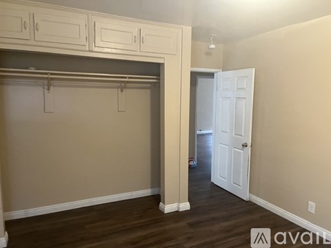 A room with a white door and a cabinet above it.