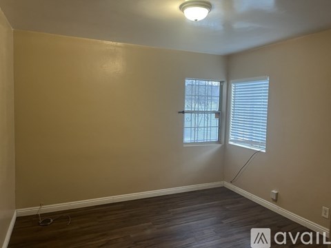 A room with a window and wooden flooring.