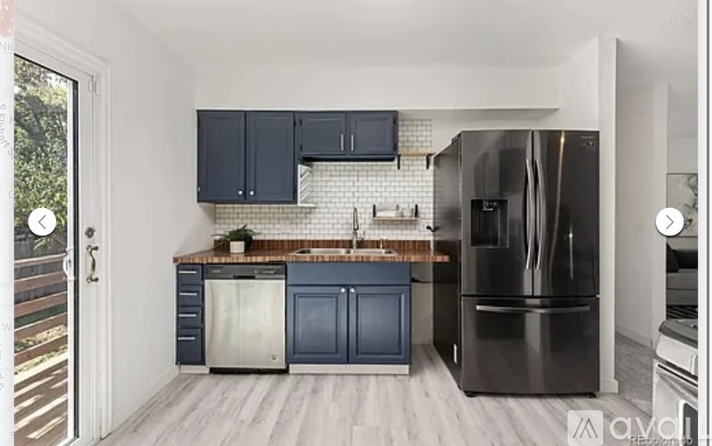 A kitchen with a black refrigerator and a black microwave.