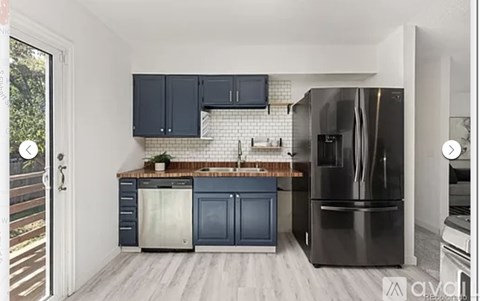 A kitchen with a black refrigerator and a black microwave.