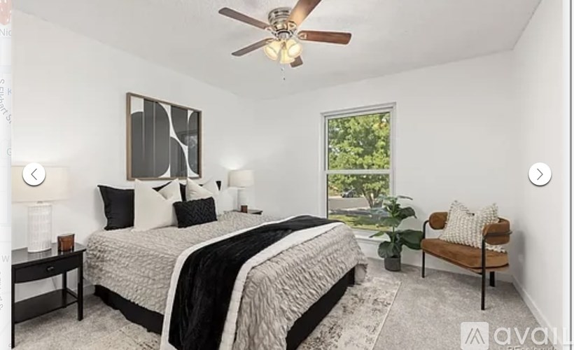 A bedroom with a large bed and a ceiling fan.