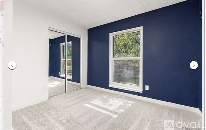 A room with a window and a door leading to another room.