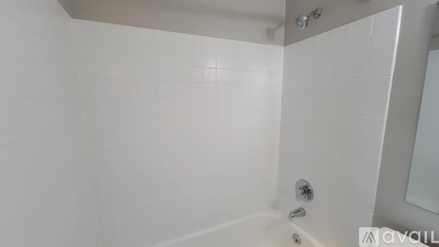 A white bathroom with a shower and a glass door.
