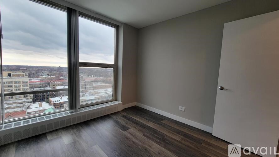 A room with a large window overlooking a cityscape.