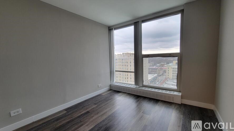 A room with a large window overlooking a cityscape.