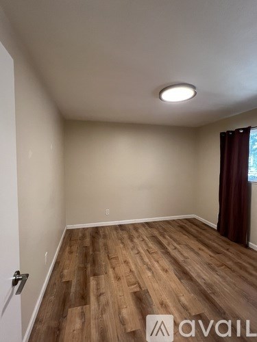 A room with wooden flooring and a white door.
