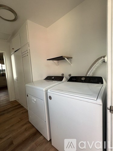 A white washing machine and dryer in a laundry room.