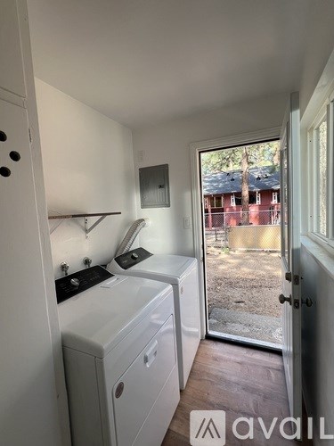 A small kitchen with a window and a view of a backyard.