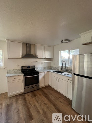 A kitchen with white cabinets and a black stove top oven.