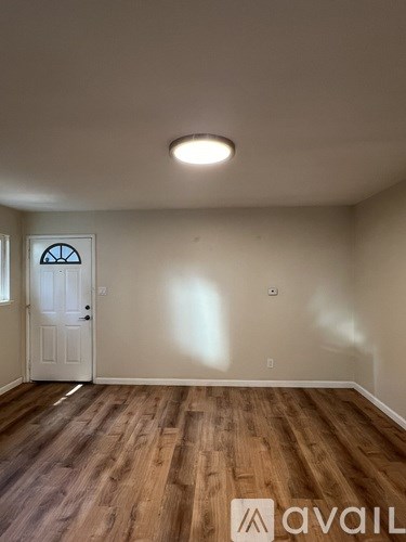 A room with wooden flooring and a white door.