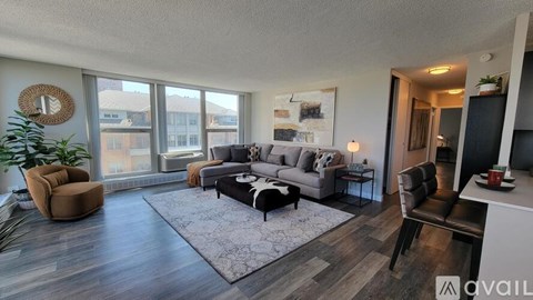 A living room with a grey couch and brown armchairs.