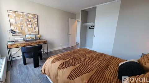 A bedroom with a bed, desk, and chair.