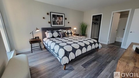 A bedroom with a bed, nightstand, and lamp.