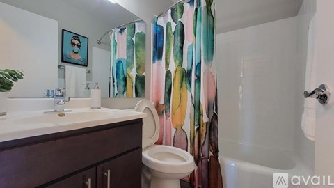 A bathroom with a toilet, sink, and shower curtain.