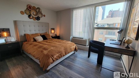 A bedroom with a large bed and a desk with a chair.