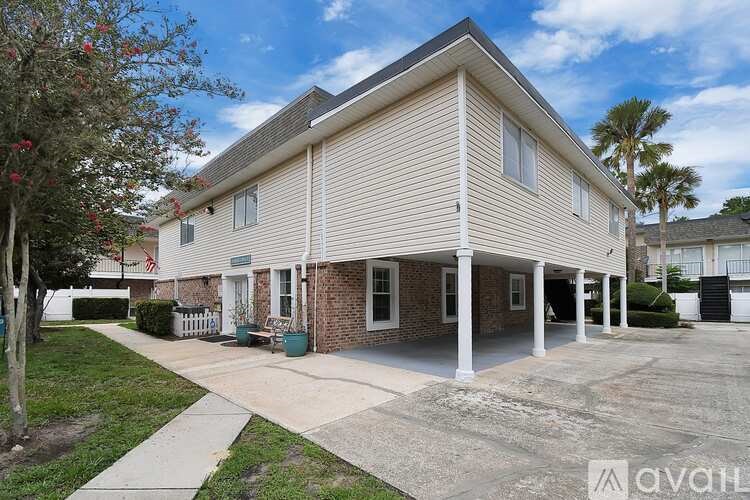 A house with a beige siding and a white porch is for sale.
