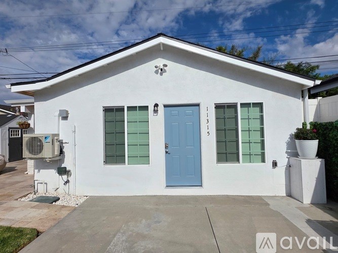 A white house with a blue door and windows.