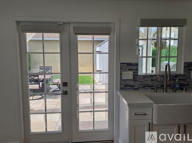 A kitchen with a sink, a window and a door leading outside.
