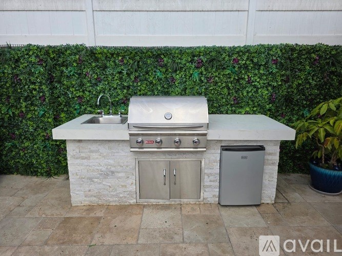 An outdoor kitchen with a grill and sink.