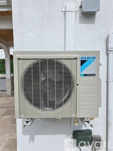 A Daikin air conditioner unit is mounted on a wall.