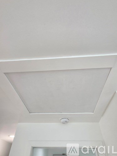 A white ceiling with a light fixture in the middle.