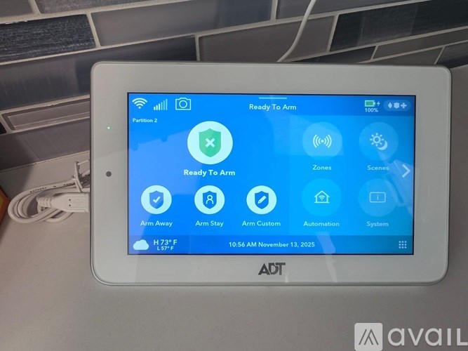 A tablet displaying a screen for a security system with the status "Ready To Arm".